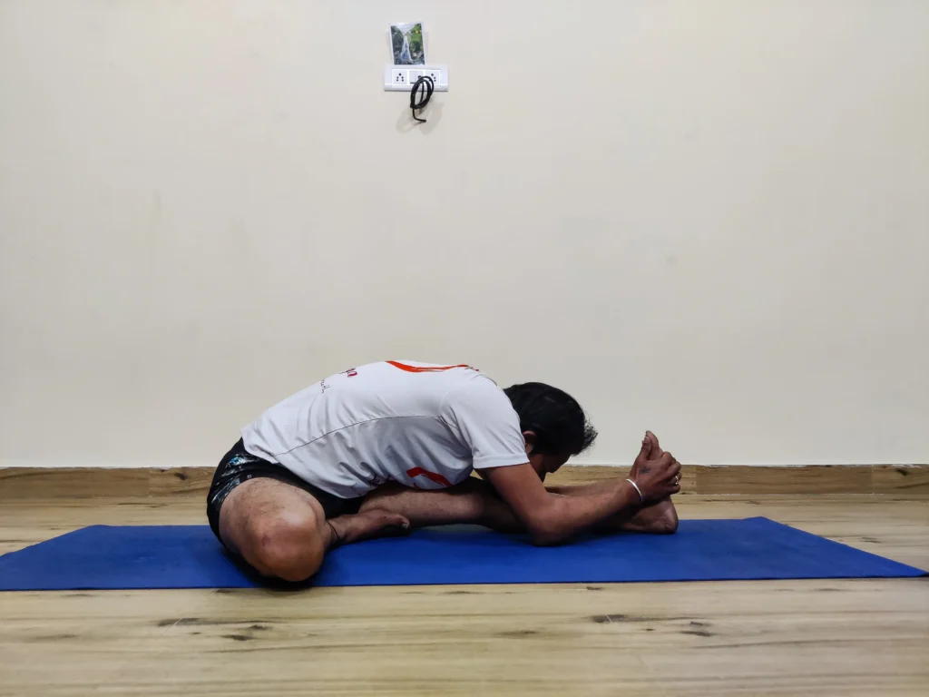 A person performing Janu Sirsasana A, a seated yoga pose with one leg extended and the other bent inward.