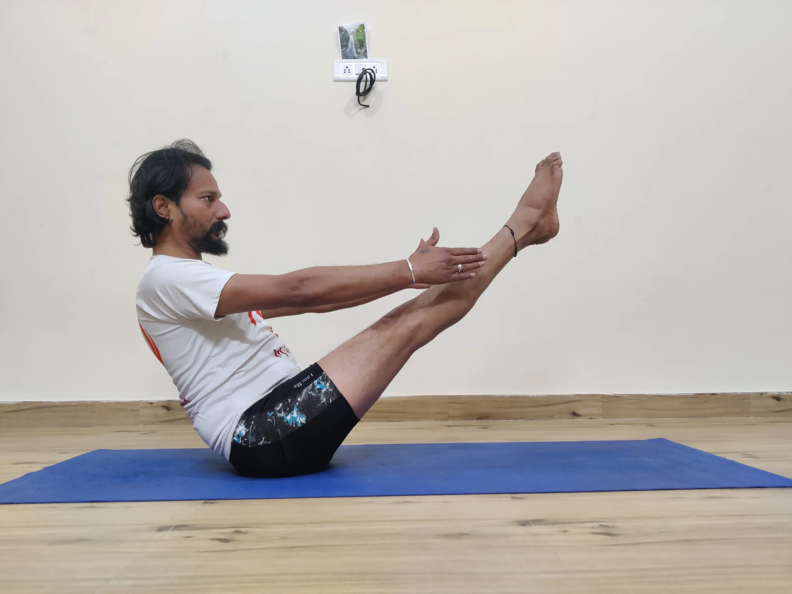 A person demonstrating Navasana, or Boat Pose, in yoga.