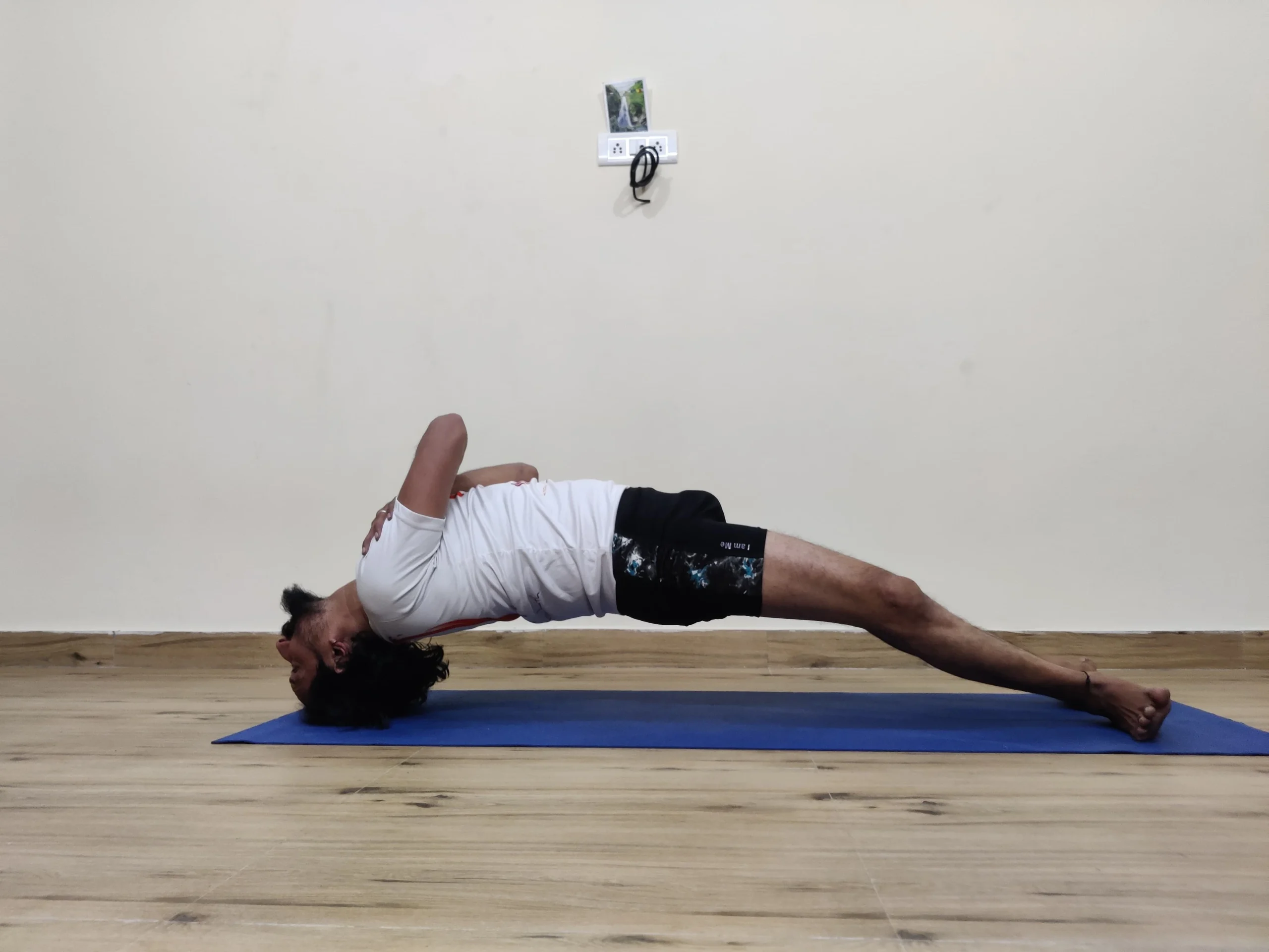 A person practicing Setu Bandhasana, or Bridge Pose, in yoga, lifting the hips upward.