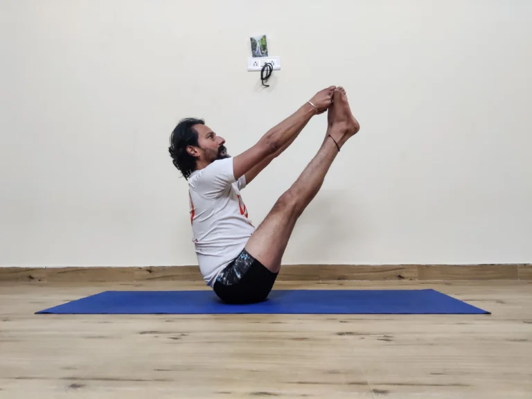 A person demonstrating Ubhaya Padangusthasana, or Both Big Toe Pose, in yoga.