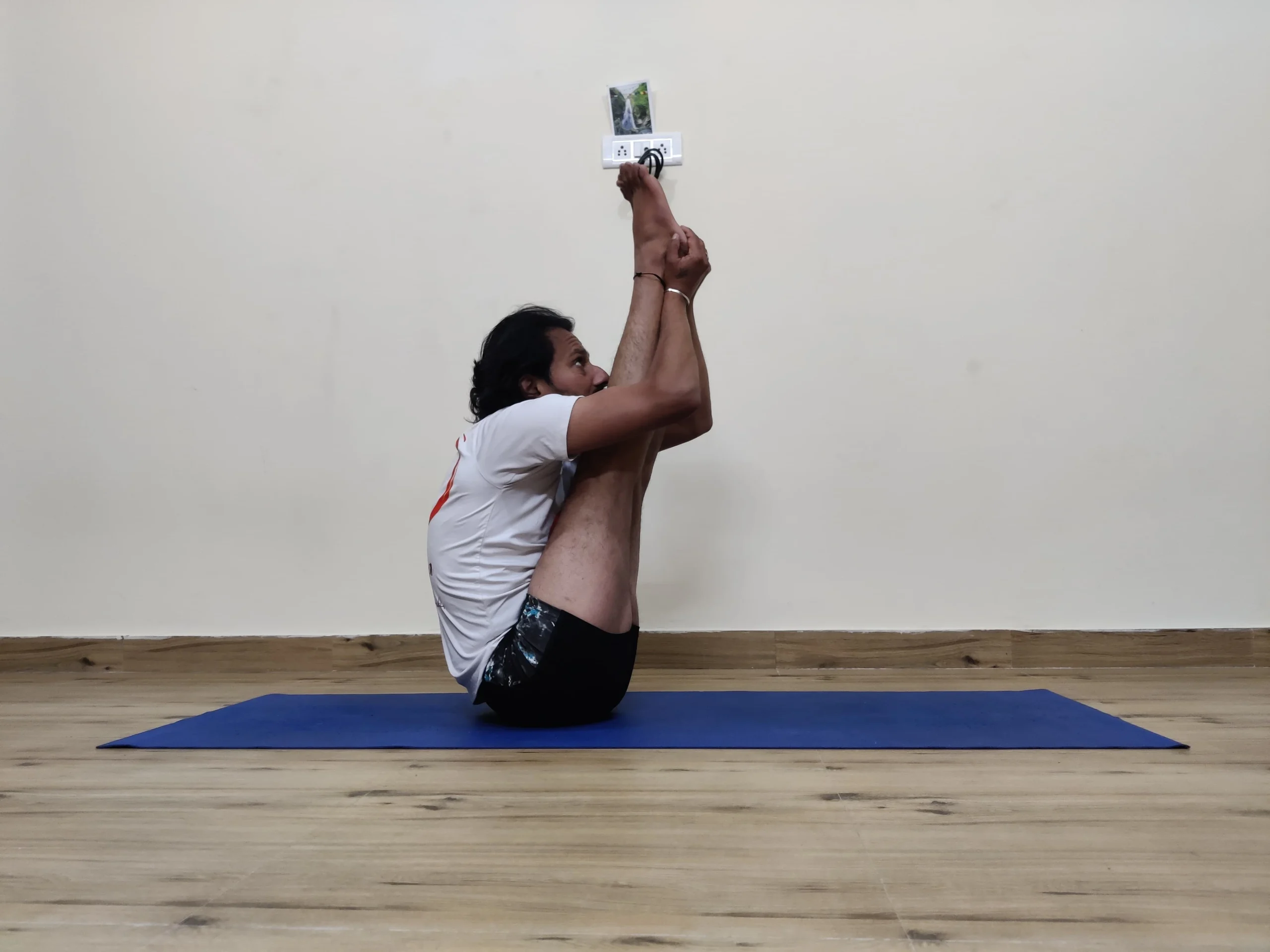 A person practicing Urdhva Mukha Paschimottasana, or Upward Facing Intense Stretch Pose, in yoga.