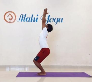 A man performing Utkatasana - Fierce Posture during yoga practice.