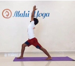 A man performing Virabhadrasana A - Warrior I Pose during yoga practice.