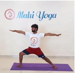 A man performing Virabhadrasana B - Warrior II Pose during yoga practice.