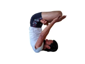 A man performing Urdhva Padmasana, an upward lotus pose in yoga, with legs crossed in lotus position and arms extended overhead.