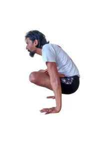 A person performing Uttpluthi, an uprooting pose in yoga, with the body lifted off the ground and supported by the hands.